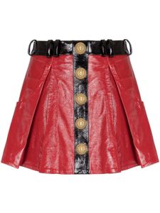 Balmain minijupe plissée en cuir à fini verni - Rouge