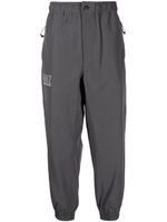 izzue x Neighborhood NHIZ pantalon de jogging à logo imprimé - Gris